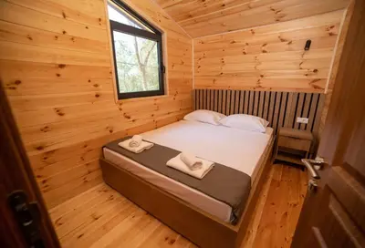 a bedroom with a bed in a wooden cabin at Villa Boga on Ada Bojana in Gornji Štoj