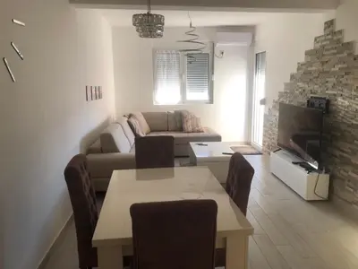 a living room with a couch and a table with chairs at Apartment Radoncic in Ulcinj