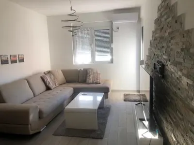 a living room with a couch and a brick wall at Apartment Radoncic in Ulcinj