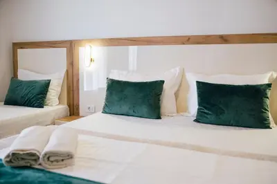 a bedroom with two beds with green and white pillows at Premium apartments in Ulcinj