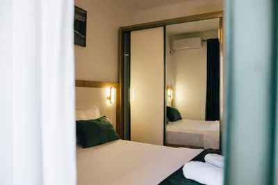 a hotel room with two beds and a mirror at Premium apartments in Ulcinj