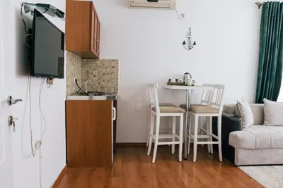 a living room with a couch and a table with chairs at Premium apartments in Ulcinj