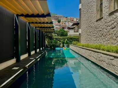 a swimming pool with blue water next to a building at Two bedroom apartment Onia - Budva in Budva
