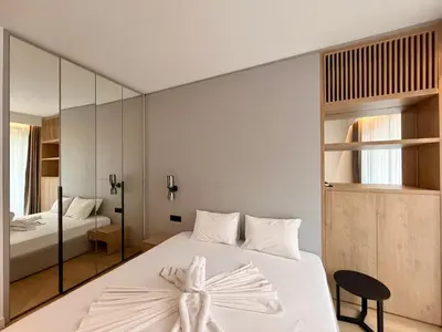 a bedroom with a white bed and a mirror at Two bedroom apartment Onia - Budva in Budva