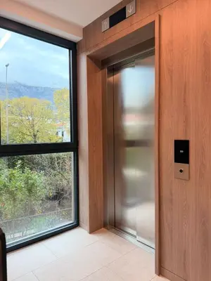 an elevator in a building with a large window at Two bedroom apartment Onia - Budva in Budva