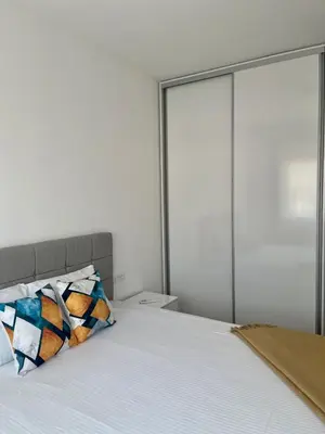 a bedroom with a bed with white sheets and glass doors at Montenegro Suite Rental in Bar