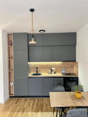 a kitchen with black cabinets and a wooden table at Montenegro Suite Rental in Bar