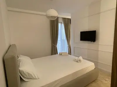 a bedroom with a bed with a tv and a window at 13 July apartment in Budva
