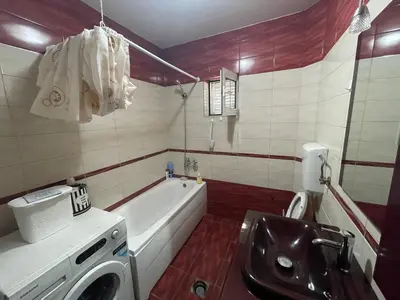 a bathroom with a tub and a sink and a washing machine at Stefhouse in Mojanovići