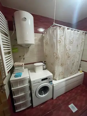 a small kitchen with a washing machine and a shower curtain at Stefhouse in Mojanovići