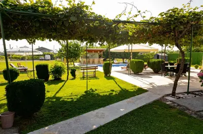 a garden with a table and chairs under a pergola at Stefhouse in Mojanovići