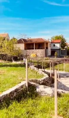 a house with a fence in front of a yard at Etno Selo - Familie Raickovic in Podgorica
