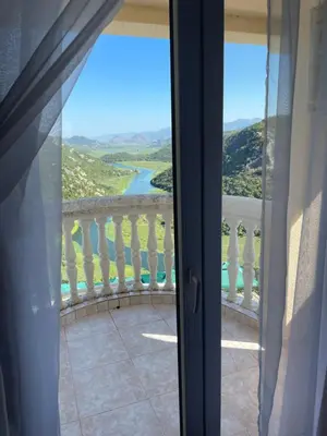 a room with a view of a river from a balcony at Konoba Ceklin in Cetinje
