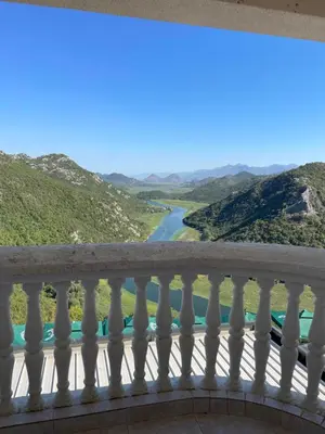a balcony with a view of a river and mountains at Konoba Ceklin in Cetinje