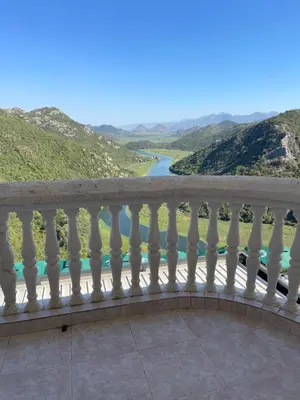 a balcony with a view of a river and mountains at Konoba Ceklin in Cetinje