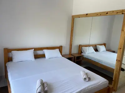 two twin beds in a room with a mirror at Konoba Ceklin in Cetinje