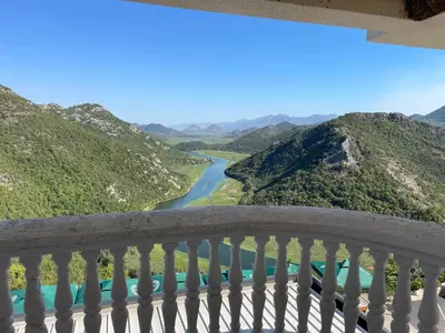 a balcony with a view of a river and mountains at Konoba Ceklin in Cetinje