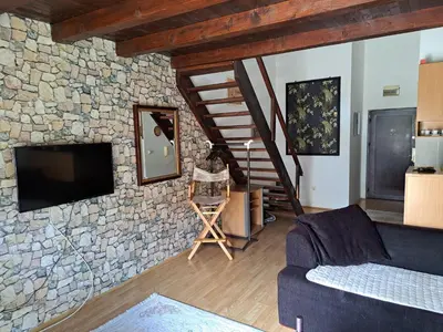 a living room with a tv and a stone wall at Gallery apartment Budva in Budva