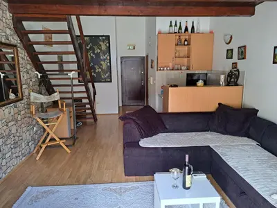 a living room with a blue couch and a staircase at Gallery apartment Budva in Budva