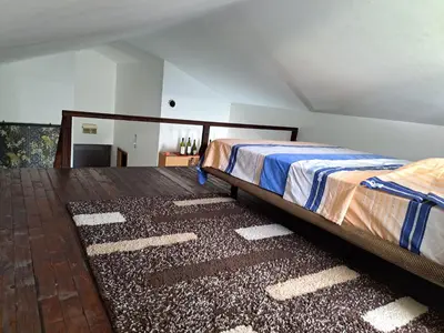 a bedroom with two beds and a rug at Gallery apartment Budva in Budva