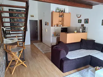 a living room with a couch and a kitchen at Gallery apartment Budva in Budva