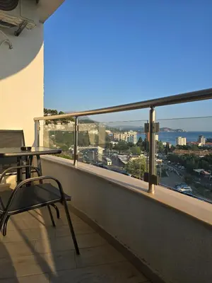 a balcony with a table and chairs and a view of a city at Juzni Horizont Apartments in Sutomore