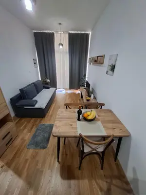 a living room with two wooden tables and a couch at Apartman One in Budva