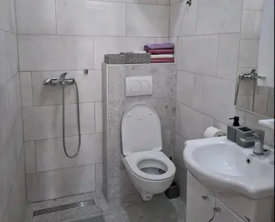 a small bathroom with a toilet and a sink at Apartman One in Budva