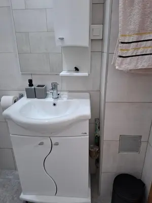a bathroom with a white sink and a mirror at Apartman One in Budva