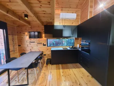a kitchen with a table and a fish tank at modernes Holzhaus, Cabin, auf dem Fluss, wenige Meter zum Meer in Ulcinj