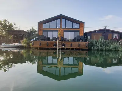 a house sitting on top of a body of water at modernes Holzhaus, Cabin, auf dem Fluss, wenige Meter zum Meer in Ulcinj