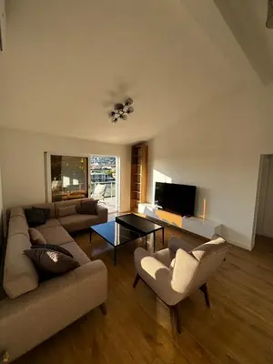 a living room with two couches and a tv at Čobrenović Penthouse in Bar