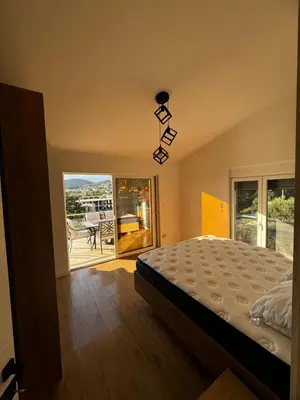 a bedroom with a bed and a balcony at Čobrenović Penthouse in Bar