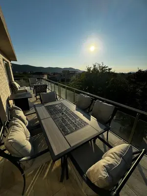 a table and chairs on a balcony with a view at Čobrenović Penthouse in Bar