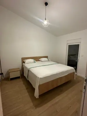a bedroom with a large bed with a white bedspread at Čobrenović Penthouse in Bar
