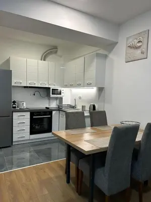 a kitchen with a wooden table and chairs at Appartement entièrement équipé neuf Budva - Appart 8 in Budva