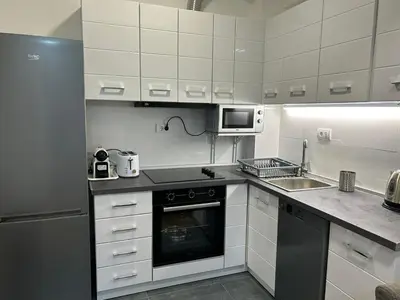 a kitchen with white cabinets and a stove and a microwave at Appartement entièrement équipé neuf Budva - Appart 8 in Budva