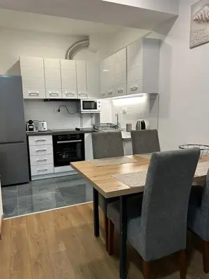 a kitchen with a wooden table and chairs at Appartement entièrement équipé neuf Budva - Appart 8 in Budva