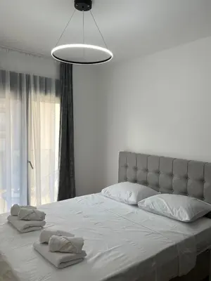 a white bedroom with a large bed with towels on it at Montenegro Luxury Suites - New City Podgorica in Podgorica