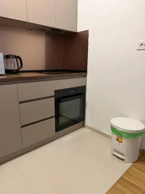 a kitchen with a stove and a trash can at Montenegro Luxury Suites - New City Podgorica in Podgorica