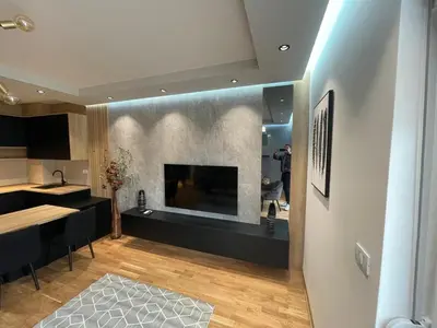 a kitchen and living room with a large fireplace at Montenegro Luxury Suites - New City Podgorica in Podgorica