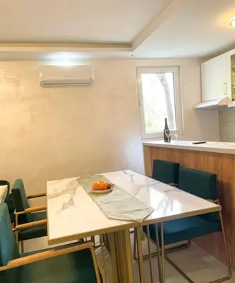 a kitchen with a table with a bowl of oranges on it at Tihanas apartment in Kotor