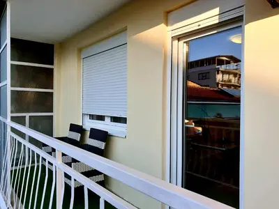 a balcony with two chairs and a sliding glass door at Apartment 081 City Center in Podgorica