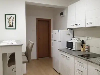 a kitchen with a white refrigerator and a microwave at Apartment 081 City Center in Podgorica