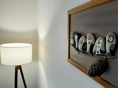 a room with a lamp and a shelf with owls at Apartment 081 City Center in Podgorica