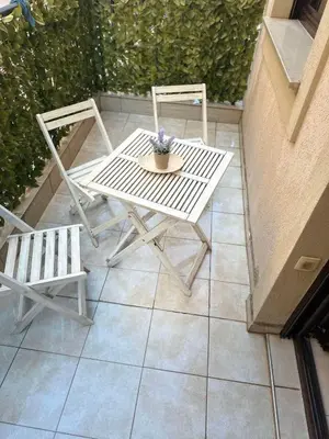 a white table and two chairs on a patio at Studio Apartment Ljilja in Budva
