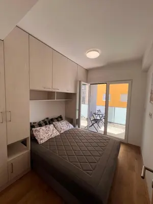 a bedroom with a large bed and cabinets at Spring Apartment in Podgorica