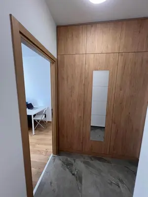 a room with a wooden wall next to a door at Spring Apartment in Podgorica