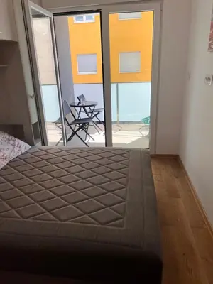 a bedroom with a bed and a view of a patio at Spring Apartment in Podgorica