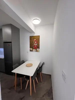 a dining room with a white table and chairs at Spring Apartment in Podgorica